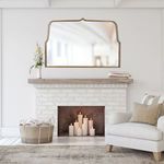 Belmont mirror mounted above white brick fireplace in cozy living room setting with candles and neutral decor