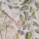 Edulis Blush wallpaper with delicate pressed flowers and green leaves on a soft pink background, shown folded