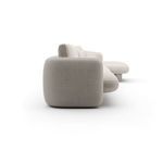 Side view highlighting rounded armrest and sculptural curves of ivory fabric sectional