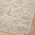 Section of rug on hardwood floor highlighting faded traditional patterns and soft color blend