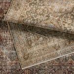 Multiple Zakaria rugs stacked, showing variations in distressed medallion patterns and color tones