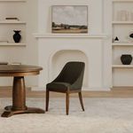 Edward dining chair set in a neutral living room with round wooden dining table and decorative shelves