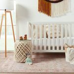 Alternate nursery view showing different angle of rug near crib, lamp, and woven basket