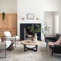rug styled in a modern living space with black sofa, light walls, and wooden coffee table