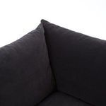 Large sectional sofa in navy styled with throw pillows near window with cityscape