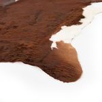 Close-up showing texture and color transition from brown to white on cowhide rug edge