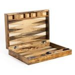 Wooden backgammon board open on wood table with dice and chips arranged for play