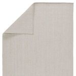 Top view showing folded corner revealing rug back with consistent light gray weave