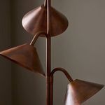 Close-up of three metal shades from slightly angled side perspective against a taupe wall.