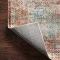 Corner of rug lifted to show tightly woven backing on dark wooden floor