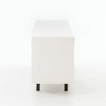 Side view of console with white lacquer surface and metal legs supporting the base