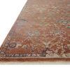 Angled close-up of terracotta rug edge showcasing pile thickness and multicolored floral border