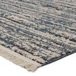 Close-up showing cut and looped pile texture and cream fringe detail on distressed blue and gray striped rug