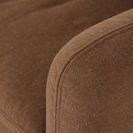 Detail of curved armrest seam and cushioning with visible fabric texture