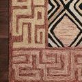 Top-down close-up of Nala Rose rug corner highlighting dense tufting and intricate earth tone design on wooden floor