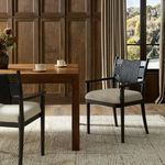 Tova Dining Armchair styled in a bright dining room with wooden table, carpet, and large window