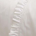 Close-up of crisp white ruffle detail along percale fabric edge