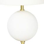 Close-up of upper part of white spherical base with brass fixture below lamp shade