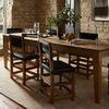 Angle view of Penny Gold / Natural Rug under dining table showing more of the room's window and stone wall