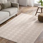 Cream geometric rug styled in living room with neutral-colored sofa, wooden flooring, and pouf