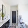 Jules runner rug positioned in bright bathroom with black vanity, white tub, patterned tile floor, and black door
