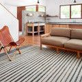 Hagen White Ocean Rug styled in modern living room with tan sofa and leather chair on hardwood floor.