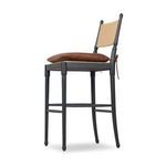 Three-quarter rear view of Fayth stool showing backrest curve and cushioned seat tied with leather strap