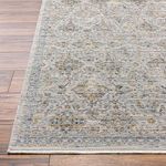 Low angle close-up of Ren Black/Blue rug corner highlighting fringe and edge stitching on wood flooring.