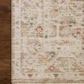 Corner of rug on dark hardwood floor, highlighting pattern detail and fringe