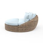 Side profile of Havana Round Daybed showing rounded wicker frame and plush cushions in light blue