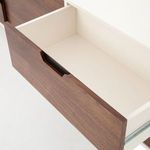 Opened drawer showing white interior and walnut front panel with recessed handle