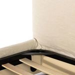 Close-up view inside bed showing wooden slats and linen slipcover