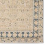 Detailed view of hand-sheared wool fibers and intricate trellis flower motifs in blue and tan tones