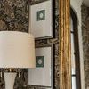 Framed Subtle Relief III painting hanging on floral wallpapered wall next to beige lamp and gold ornate mirror with partia...