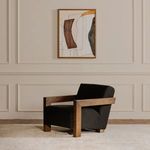 Voyager painting hanging above a black armchair in a neutral tone room with paneled walls