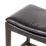 Detailed close-up of padded leather seat with its folded edge stitching on Aya Stool