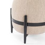 Close-up of black wooden leg and fabric band of Sia Ottoman