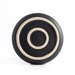 Underside of a matte black ceramic salad plate revealing two concentric circular ridges on natural clay
