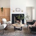 Rug showcased in modern living room with white walls, black accents, and natural wood coffee table