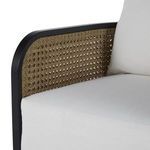 Side view of chair showing curved back and arm with natural resin weaving and black frame