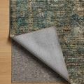 Corner flipped to show rug’s washable polyester backing and fabric layers over wooden floor