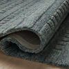 Curled corner of Bradley Teal Rug showing backing and thickness