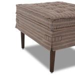 Lower side corner of ottoman showing fabric skirt, striped pattern, and tapered wood leg