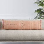 Lumbar pillow on sofa with visible tribal embroidery in textured blush and cream threads