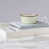 White Bianca Rectangle Tray holding stacked books and a decorative bowl, seen from side angle