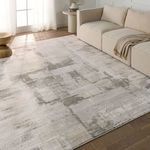 Rug placed in living room setting under beige sectional sofa, showing scale and room context