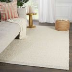 Rug in living room setting under sofa and side table, showcasing its scale and cozy look