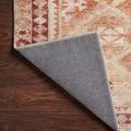 Back corner flipped to reveal non-slip textured rug backing in gray fabric
