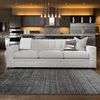 Barkley Charcoal Rug laying flat on wood floor in modern kitchen living room setting with sofa behind