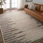 Patra rug styled in living room with leather sofa, natural light, and woven basket plant